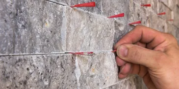 A person holding two red arrows on top of a wall.