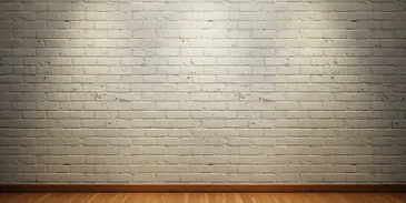 A white brick wall with wood floors and a light.