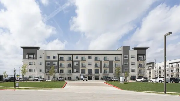 A large building with cars parked in front of it.